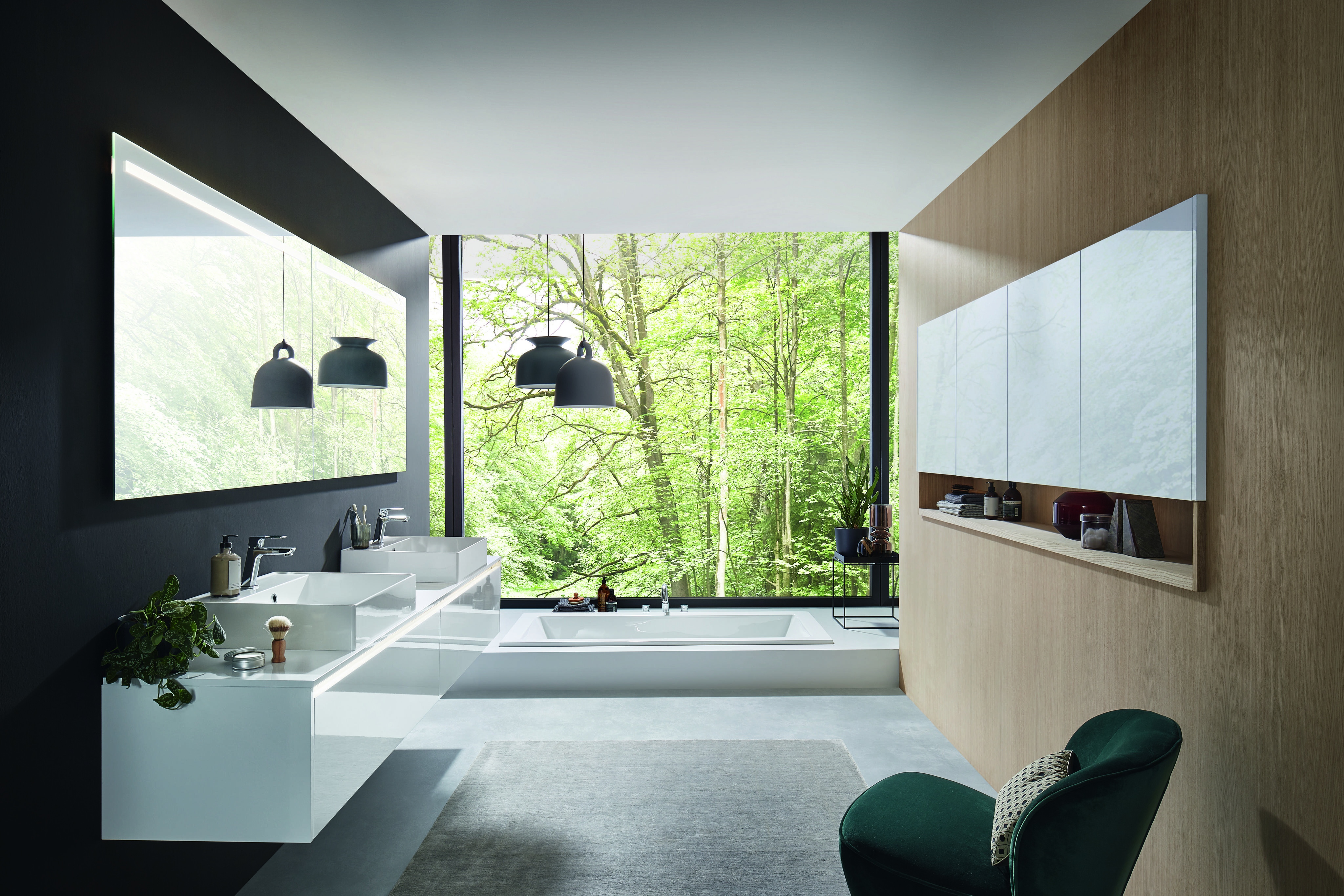 Modernes Badezimmer mit großen Fenstern und Blick ins grüne, bewaldete Außengelände.