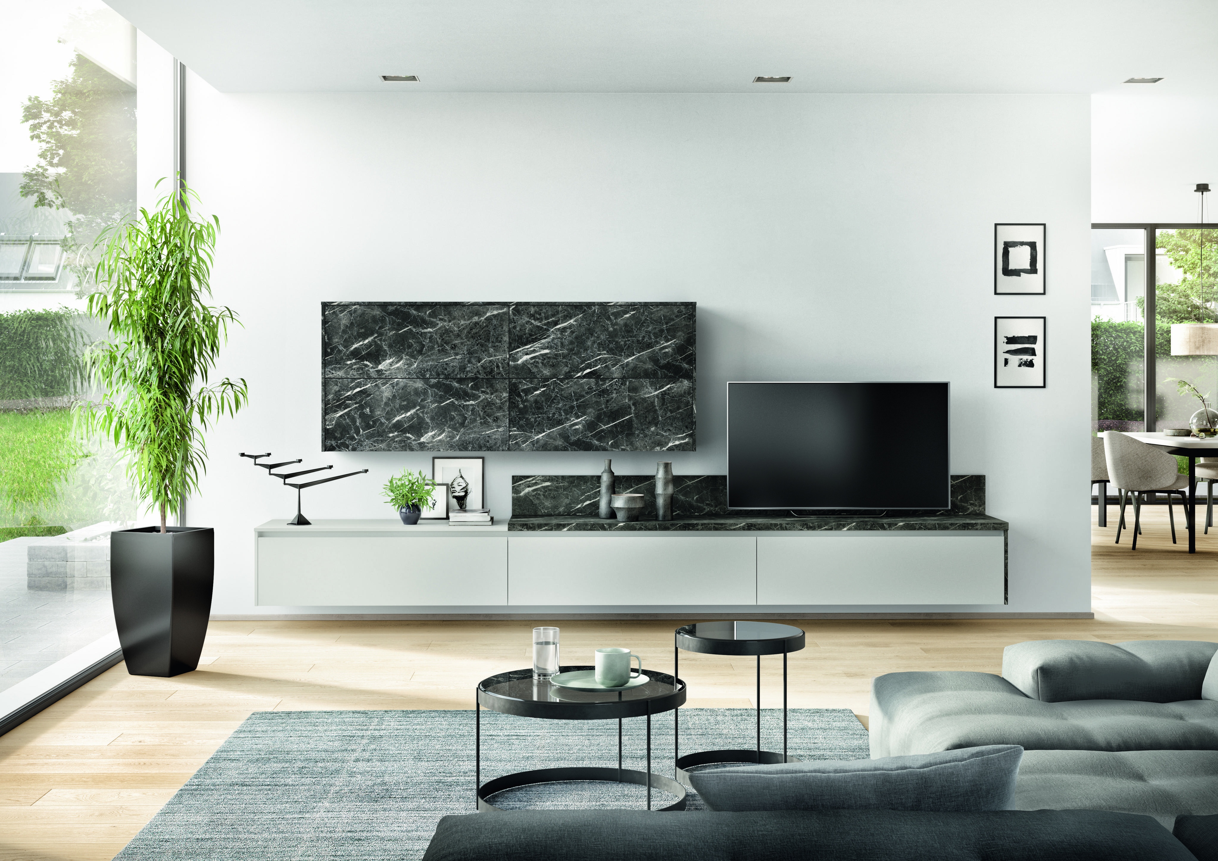 Modernes Wohnzimmer mit grauem Sofa, Couchtisch, großem Fernseher und grüner Pflanze am Fenster.