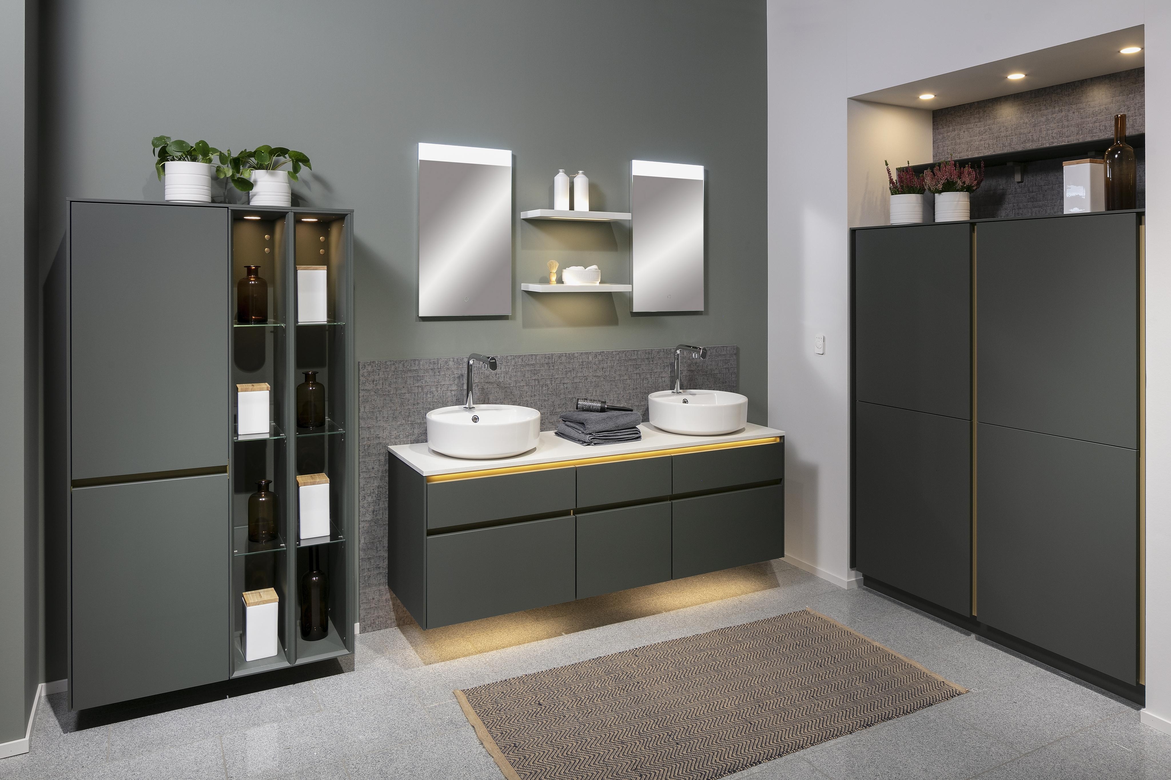 Modernes Badezimmer mit Doppelwaschbecken, Spiegeln, dunklen Schränken und Pflanzen.