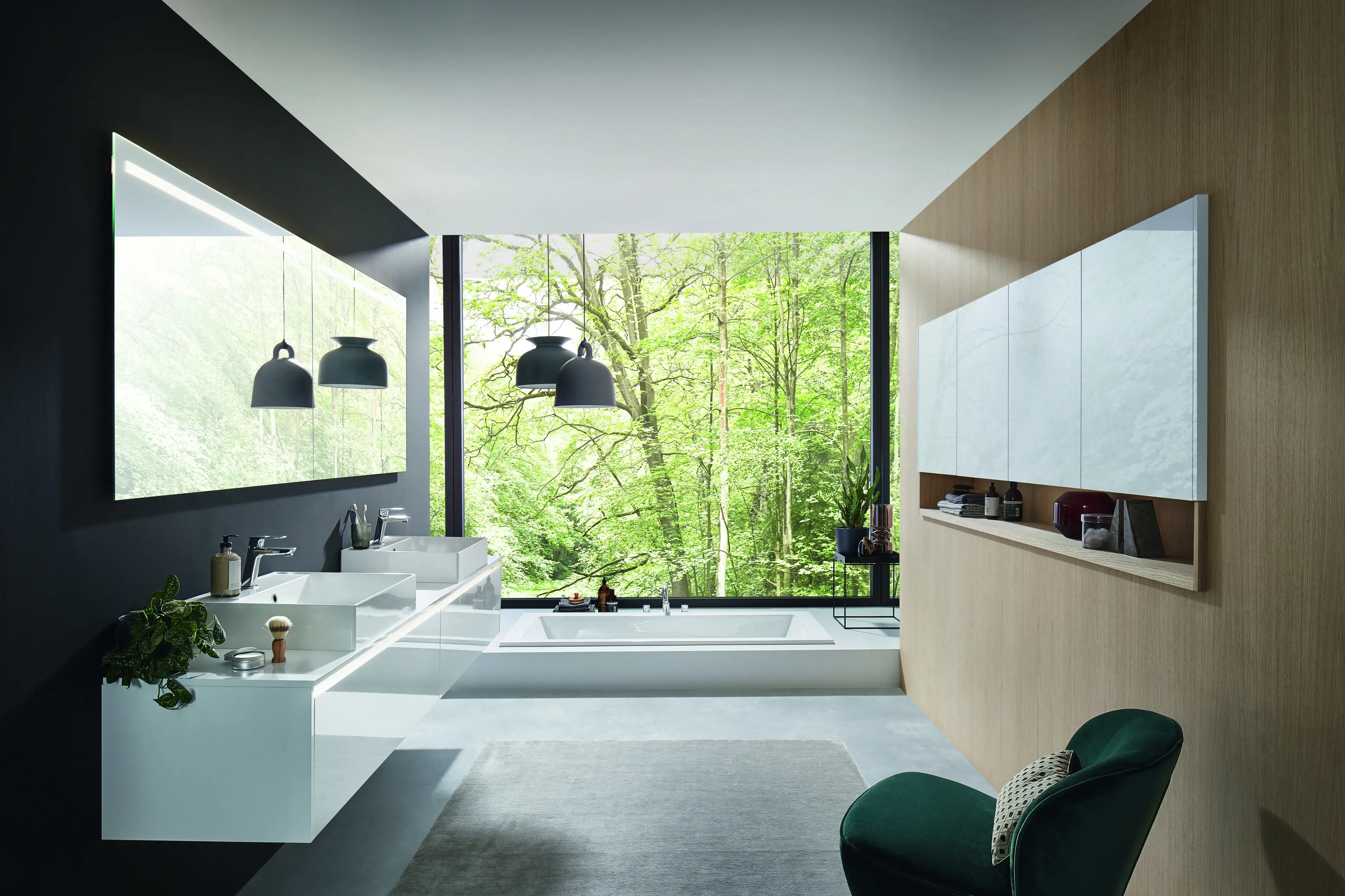 Modernes Badezimmer mit großen Fenstern und Blick ins grüne, bewaldete Außengelände.