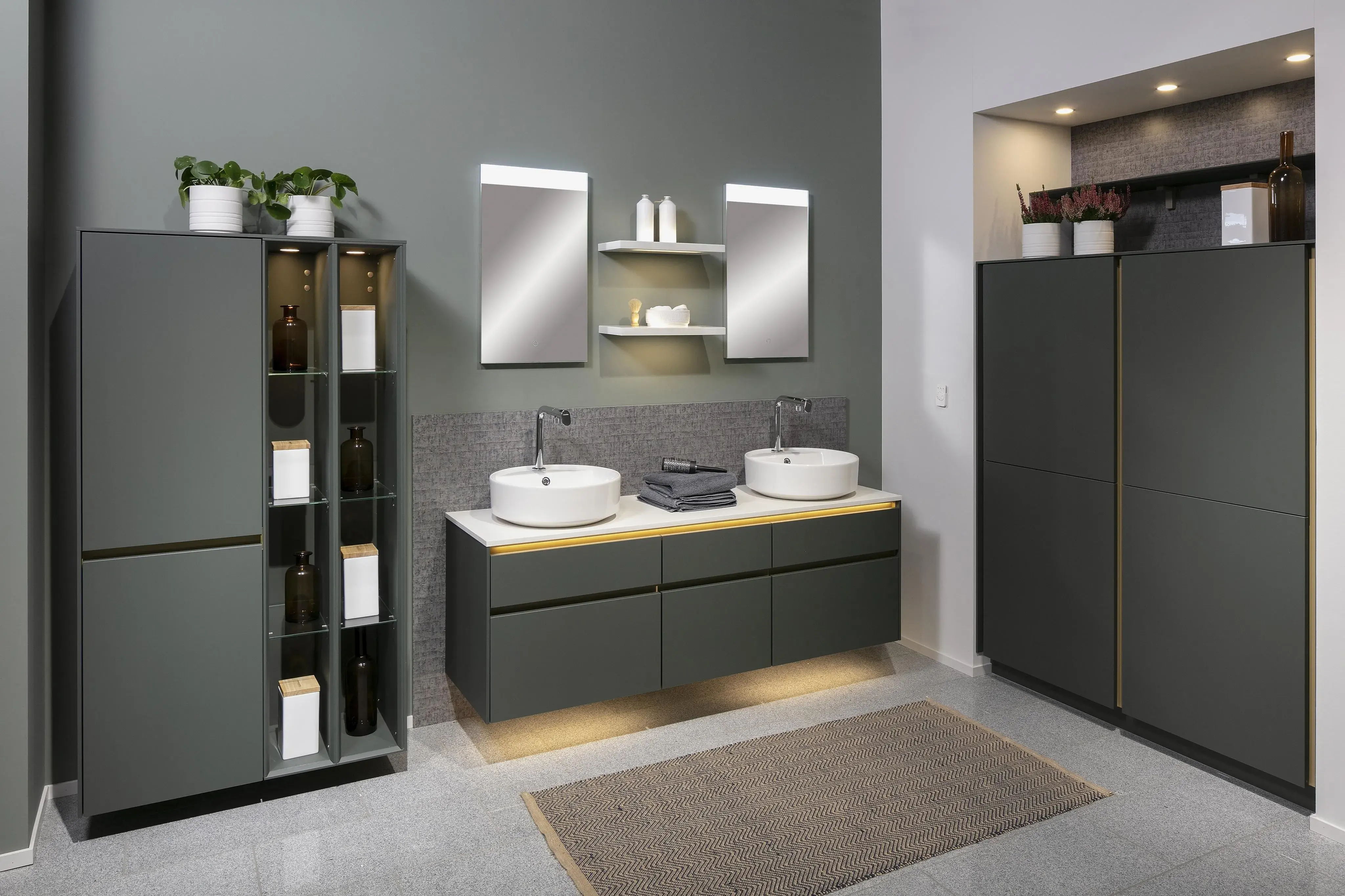 Modernes Badezimmer mit Doppelwaschbecken, Spiegeln, dunklen Schränken und Pflanzen.